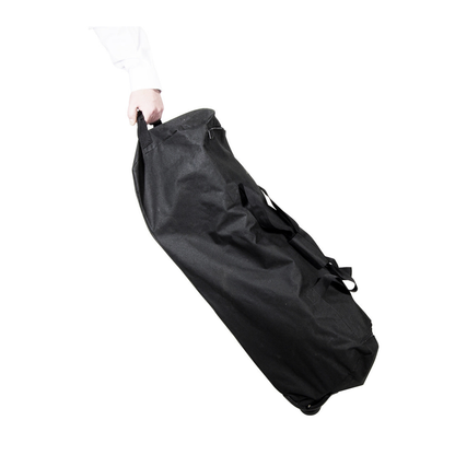 A person holds the ultra compact black rolling travel bag for the Drive Travelite Transport Chair by its handle, set against a white background—perfect for easy transport of your chair.