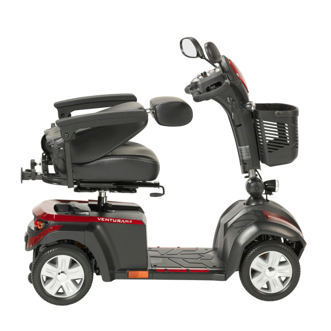 The Drive Ventura 4-Wheel HD Bariatric Scooter, shown in red and black in profile on a white background, features a high-back cushioned seat, armrests, rearview mirrors, and a front basket.
