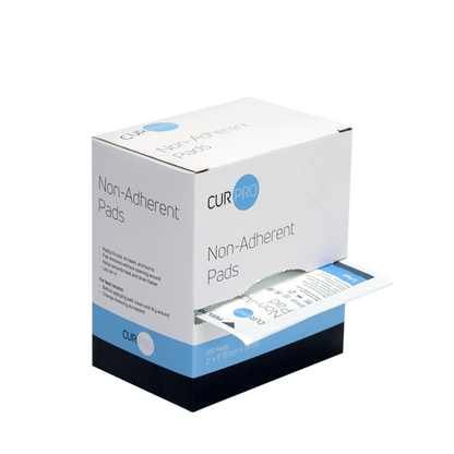 A white and blue box labeled Dynarex Non-Adherent Dressing Pads - Sterile with one partially pulled-out pad, displayed on a white background. The box contains 100 sterile 2 x 3 inch pads, ideal for gentle wound protection.