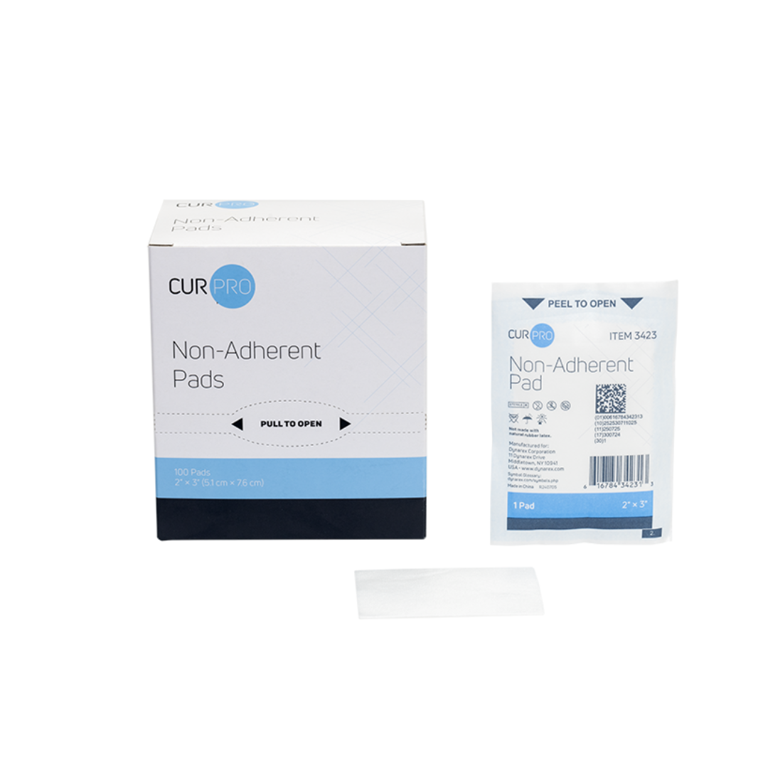 A box of Dynarex Non-Adherent Dressing Pads - Sterile, with one individually wrapped and one unwrapped pad shown on a white background. Each 2 x 3 inch pad provides gentle, sterile wound protection; box contains 100 pads.