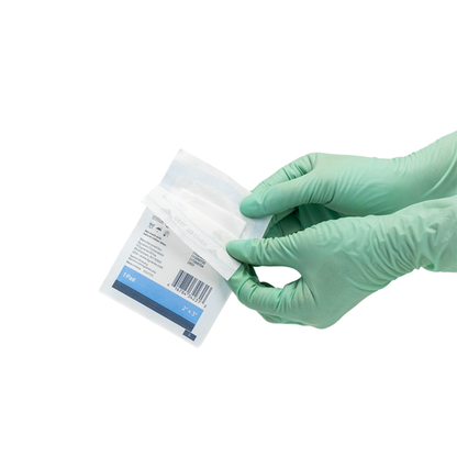Gloved hands open a sterile medical package with a barcode and blue label, revealing Dynarex Non-Adherent Dressing Pads - Sterile for wound protection, on a clean white background.