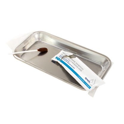 A metal tray holds a single Dynarex Povidone Iodine Swabstick in its packaging, commonly used as an antiseptic for skin preparation before medical or surgical procedures.
