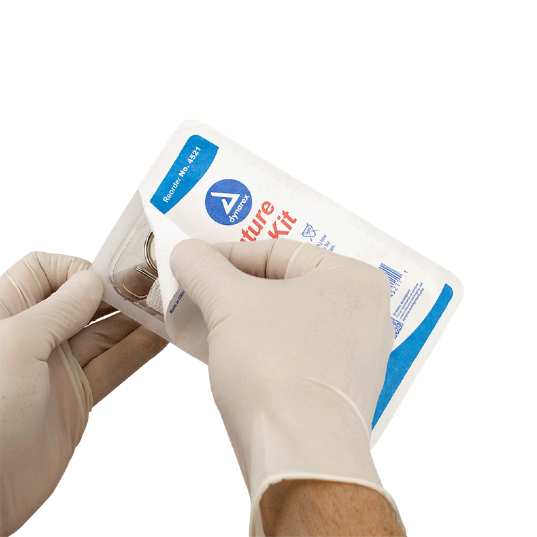 A person wearing white medical gloves opens a sterile Dynarex Staple & Suture Removal Kit package against a white background. The kit appears to contain surgical instruments.