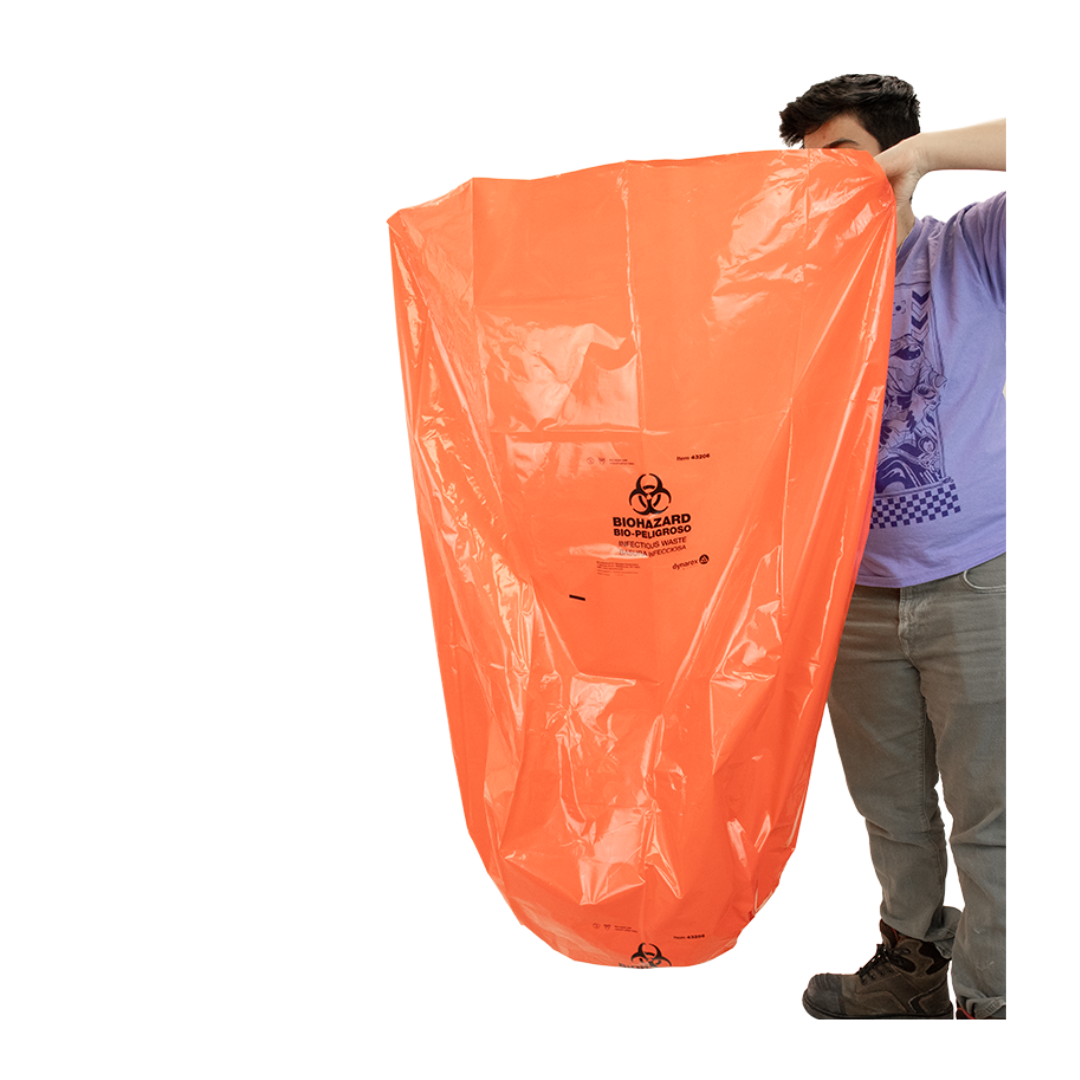 A person holds up a large orange Dynarex Biohazard Waste Bag, partially covering their face and upper body. The bag displays a biohazard symbol and text, designed for secure containment. The background is plain white.