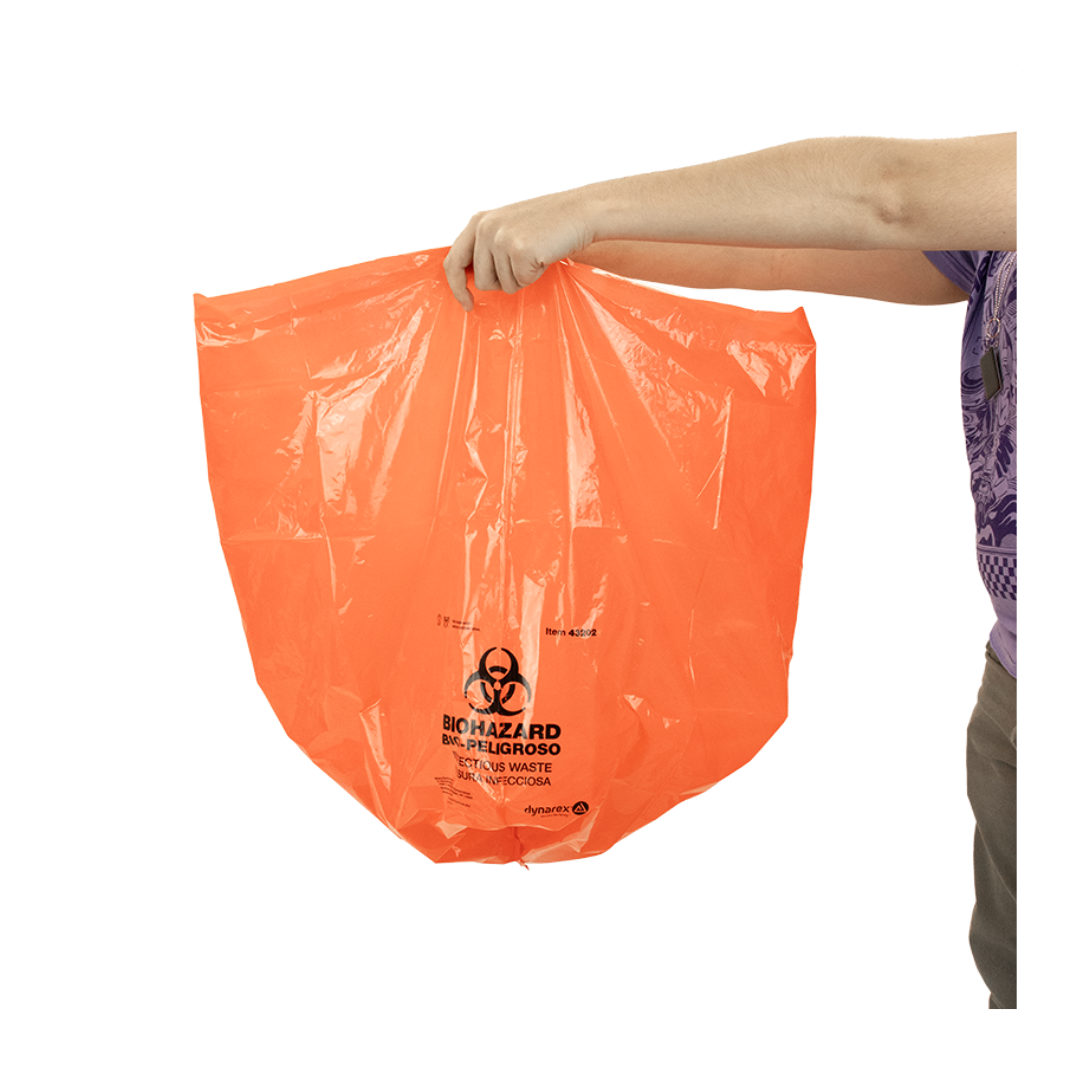 A person holds an orange Dynarex Biohazard Waste Bag with black warning symbols, gripping the empty bag at the top to ensure safe and secure containment of hazardous materials in medical or laboratory environments.