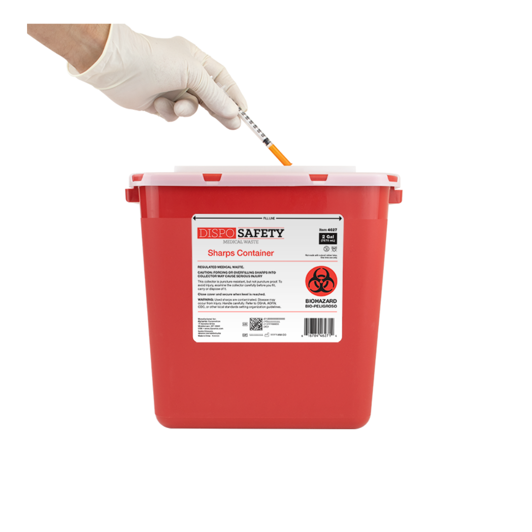A gloved hand disposes of a syringe into a Dynarex Sharps Container, a red medical waste bin with a white lid and warning label, demonstrating safe sharps disposal with Dynarex Sharps Containers.