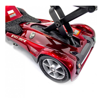 Close-up of the rear section of a shiny red EV Rider TranSport S19AF Automatic Folding Travel Scooter, showing the wheel, platform, and folded black seat support.
