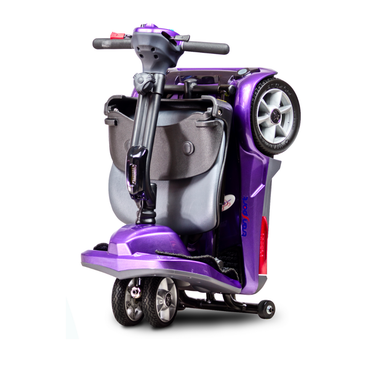 The EV Rider TranSport M Easy Move S19M Travel Scooter in purple is compact and lightweight, shown upright and folded with handlebars and seat down, standing securely on its smaller rear wheels.