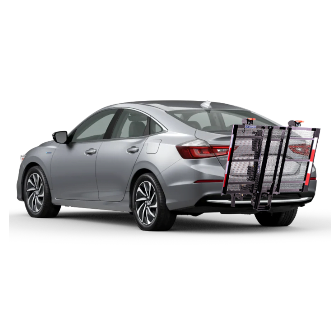 A silver sedan with an EZ-Carrier Electric Lift – Manual Fold Up (Semi-Auto) attached to the rear, featuring a metal cargo carrier, foldable ramp, and red safety reflectors. Check specs or watch videos for more details.