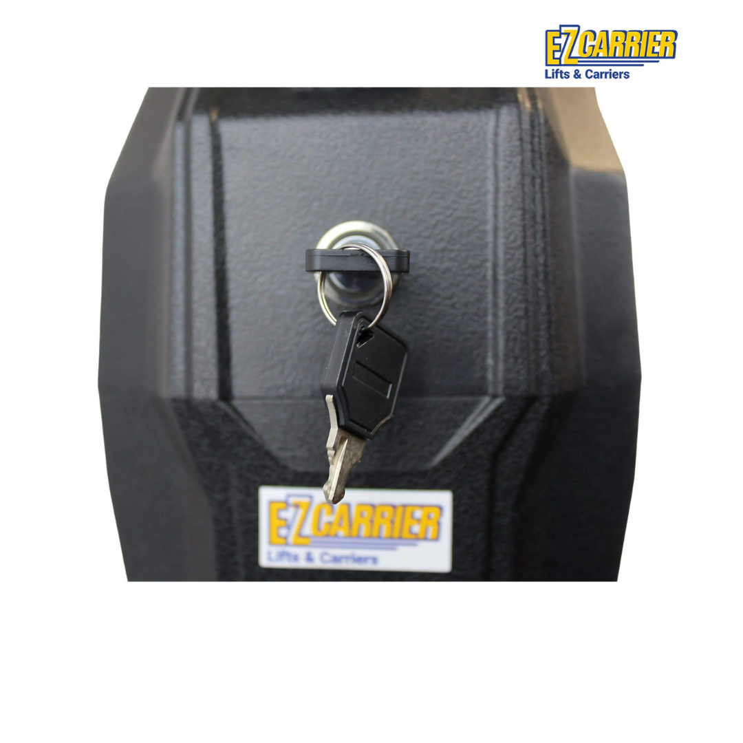 A close-up of a black lockbox with a key inserted, featuring the EZCarrier Lifts & Carriers logo. Explore specs and downloads for the EZ-Carrier Electric Lift – Manual Fold Up (Semi-Auto) on our website.