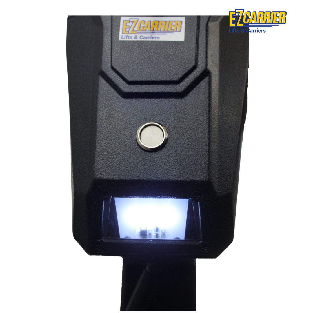 Close-up of the EZ-Carrier Electric Lift – Manual Fold Up (Semi-Auto) with a textured black surface, central metallic button, illuminated white LED display with specifications, and the EZ Carrier logo in the top right corner.