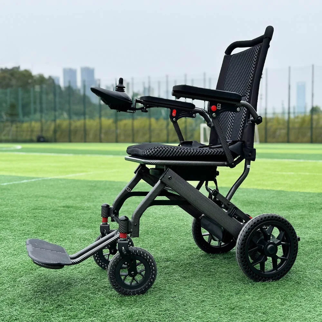 The Easwe™ E10 Portable Lightweight Electric Wheelchair, featuring a black frame and mesh seat, is placed on green artificial turf with trees and tall buildings visible in the background.