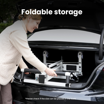 A person places the VOCIC AY06 Electric Folding Patient Transfer Lift with black handles into a car trunk. Text above reads “Foldable storage,” and a note below says, “Please check if the size can be placed in the trunk.”.