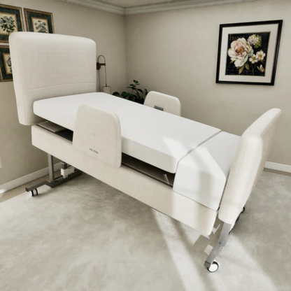 The Elevra Deluxe Rotating Hi-Lo Lift Assist Bed, with padded headboard and footboard, is shown elevated in a bright room featuring beige walls, floral artwork, and framed pictures.