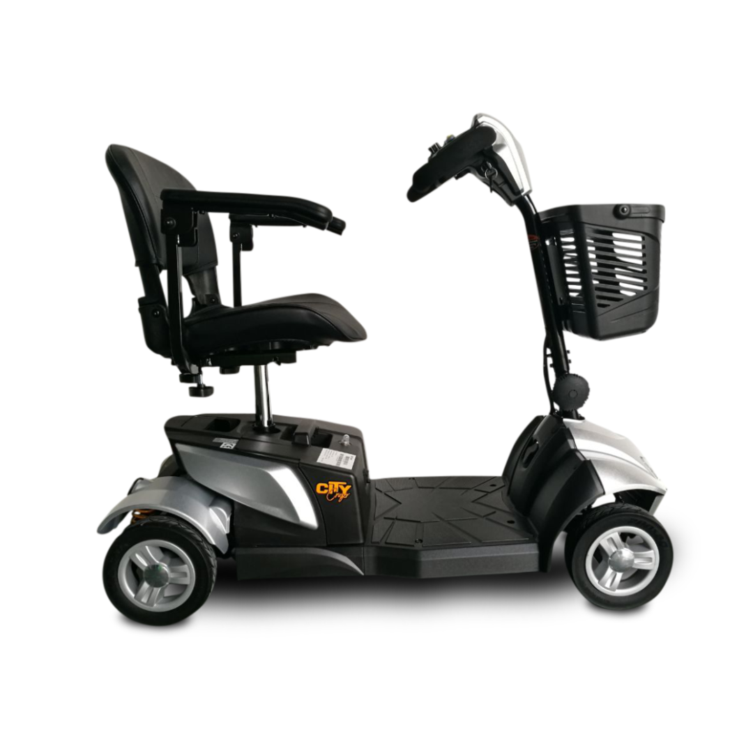 The EV Rider CityCruzer Portable Scooter is shown in black and silver with a front basket, padded seat with armrests, and handlebar controls, displayed from the side on a white background.