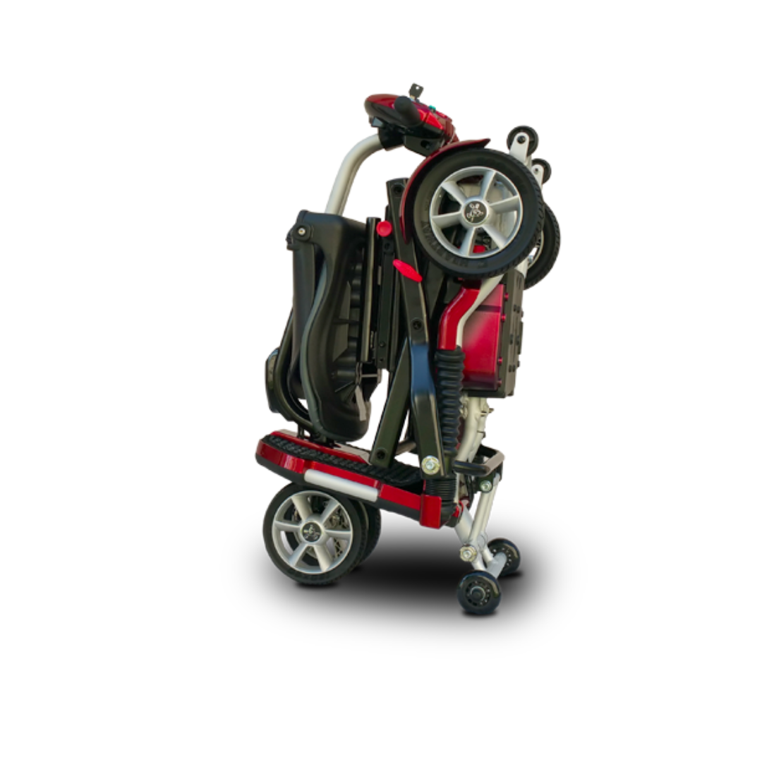 The EV Rider Transport Plus Portable Mobility Scooter, shown in red and black, stands folded upright on its wheels against a white background, offering a compact and airline-safe mobility solution.