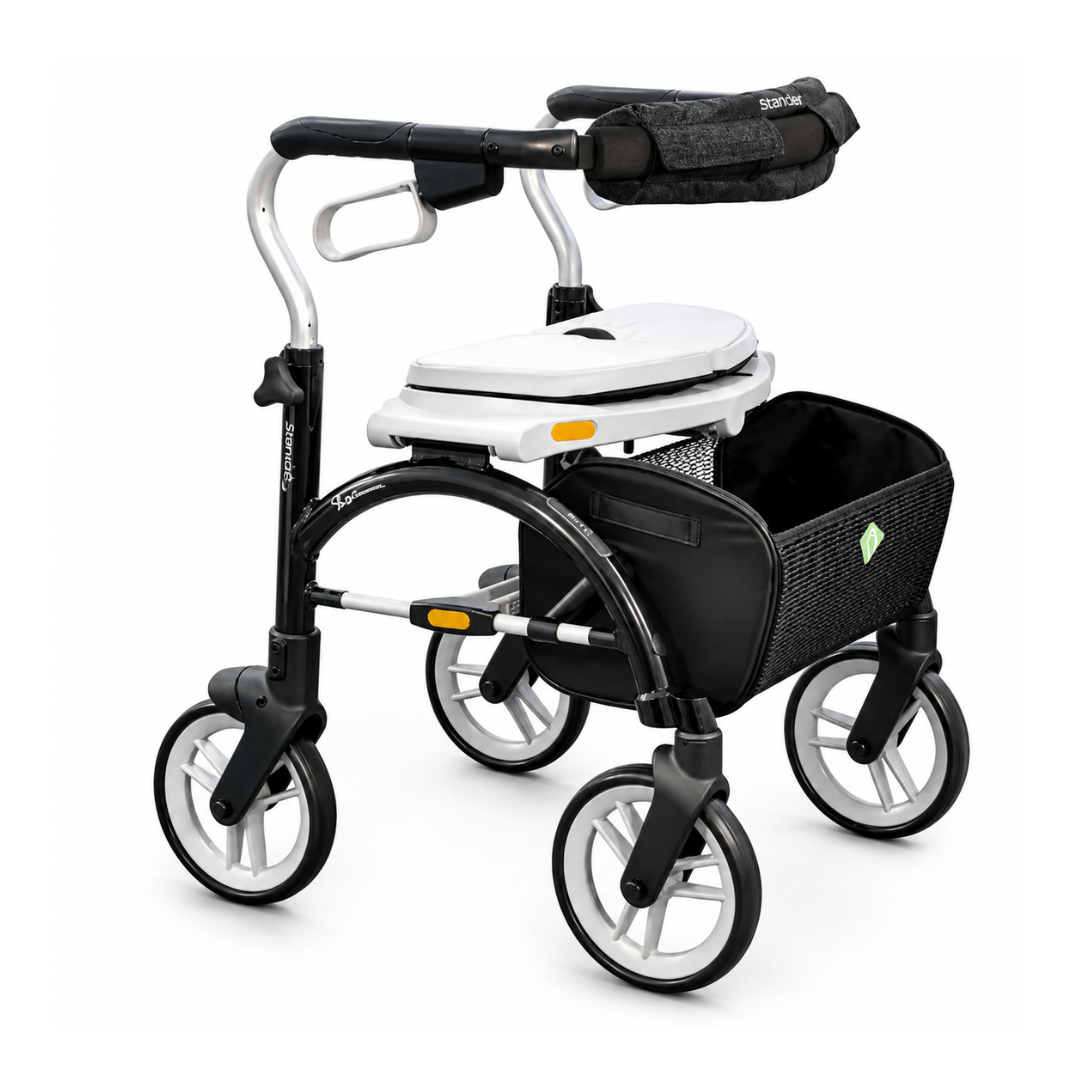 The Evolution Xpresso Lite Carbon Fiber Rollator is an ultra-light walker in black and white with four large wheels, padded armrest, a built-in seat, removable white commode, and a black mesh storage basket.