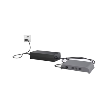 An External Battery Charger for TOC3 Rhythm O2 Concentrator is plugged into a wall outlet and connected to a gray TOC3 device with vents, both resting on a white surface.