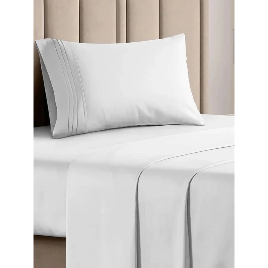 A white pillow with triple-pleated detailing resting on a bed made with matching white sheets from the Ez Elite Comfort Twin / Twin XL Size Sheet Set.