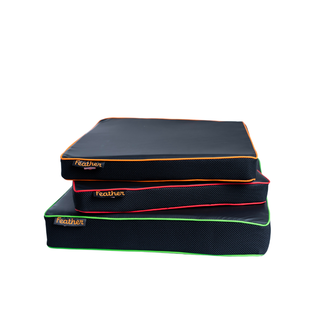 Three Feather Portable Cushions with black, water-resistant surfaces, colorful piping (orange, red, green), and handy handles are stacked together; each is labeled "feather" in the corner.