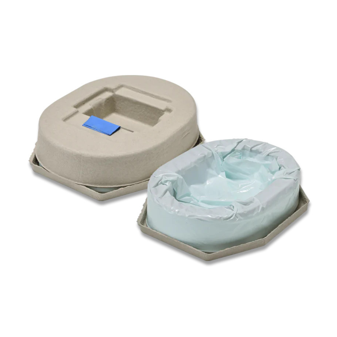 The Film Cassette for Wrappon ORB Commode includes two beige, disposable trays—one open with a blue absorbent pad and liner, one covered with a blue rectangular label—providing sanitary sealing like portable toilet replacements.