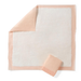 A large, square Medline FitRight Underpad with a peach border and white center is shown flat with one corner folded back, next to a matching folded pad. Known for high absorbency and disposable convenience.