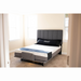 In a bright room with light walls and a beige carpet, the Flexabed Hi-Low SL Adjustable Bed features customizable height settings. The dark gray upholstered headboard and base complement its white mattress with back support, topped with a neatly folded blue blanket at the foot.