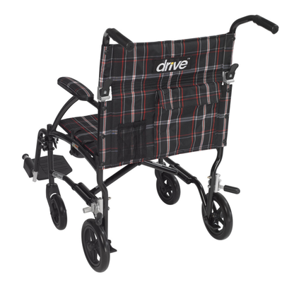 The Drive Fly-Lite Aluminum Transport Chair is a portable wheelchair with a black frame, plaid fabric seat and backrest, armrests, footrests, push handles, and "ultra-lightweight transport chair by drive" printed on the backrest.