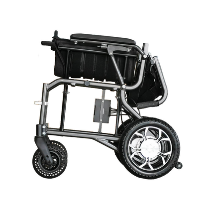 The Foldawheel ECO Lightweight Folding Powerchair is shown folded, featuring large rear wheels, smaller front wheels, and a compact frame for easy transport and storage.