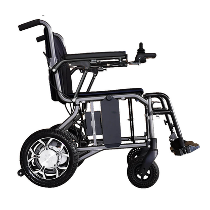 A side view of the Foldawheel ECO Lightweight Folding Powerchair shows large rear wheels, small front wheels, a footrest, and a right-arm joystick. Its metallic frame has a cushioned seat and backrest for comfort.