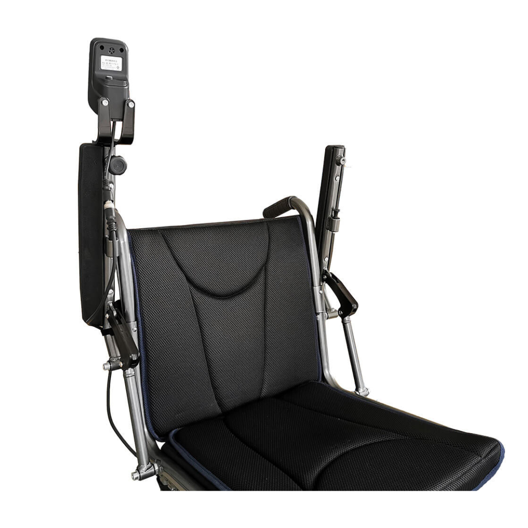 A close-up of the Foldawheel ECO Lightweight Folding Powerchair features a black padded seat, armrests, and a left-mounted control device against a white background.