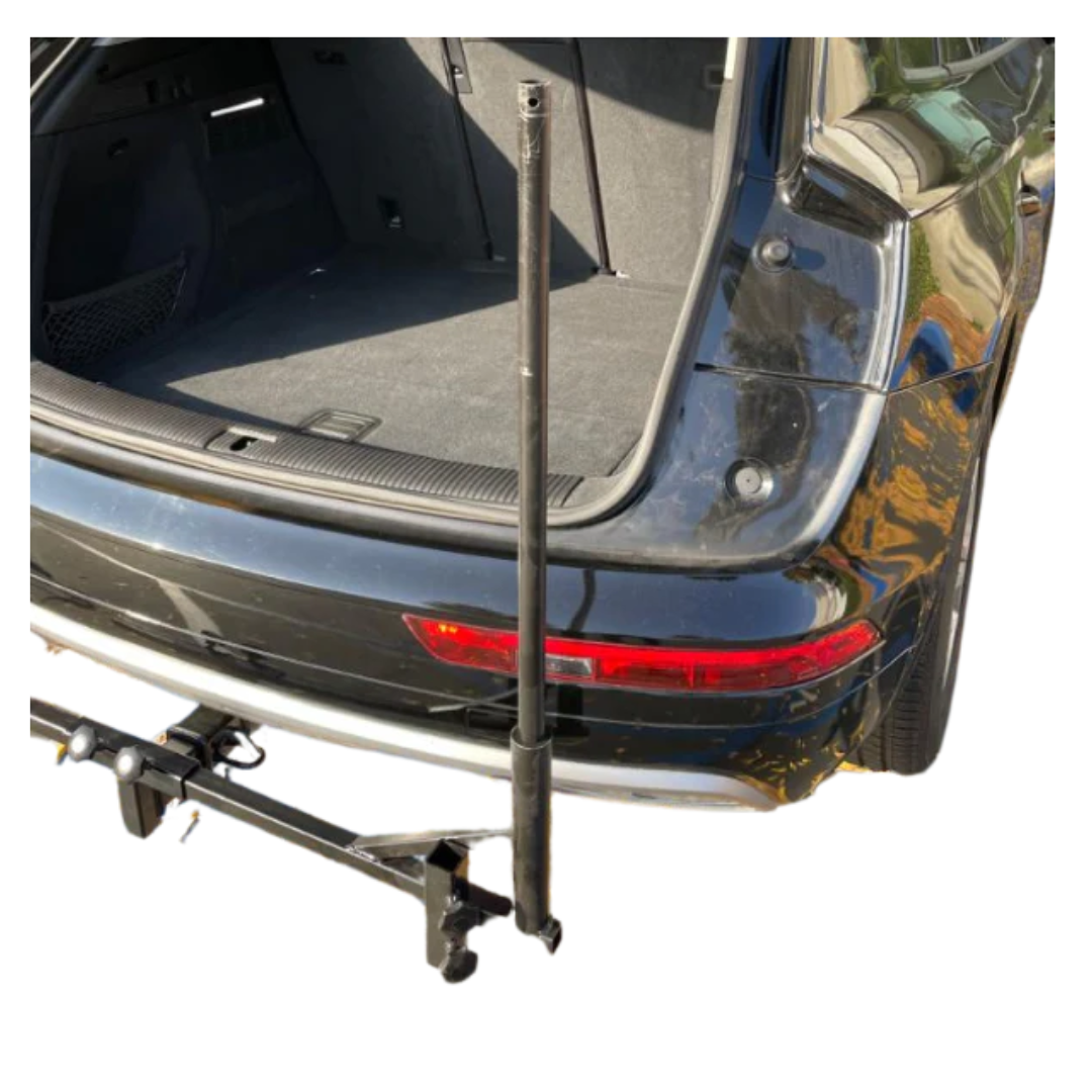 A close-up of the open trunk of a black car featuring the FreeRider Scooter Lift For Vehicles, a hitch-mounted vertical pole system designed for easy and convenient portable mobility scooter transport.