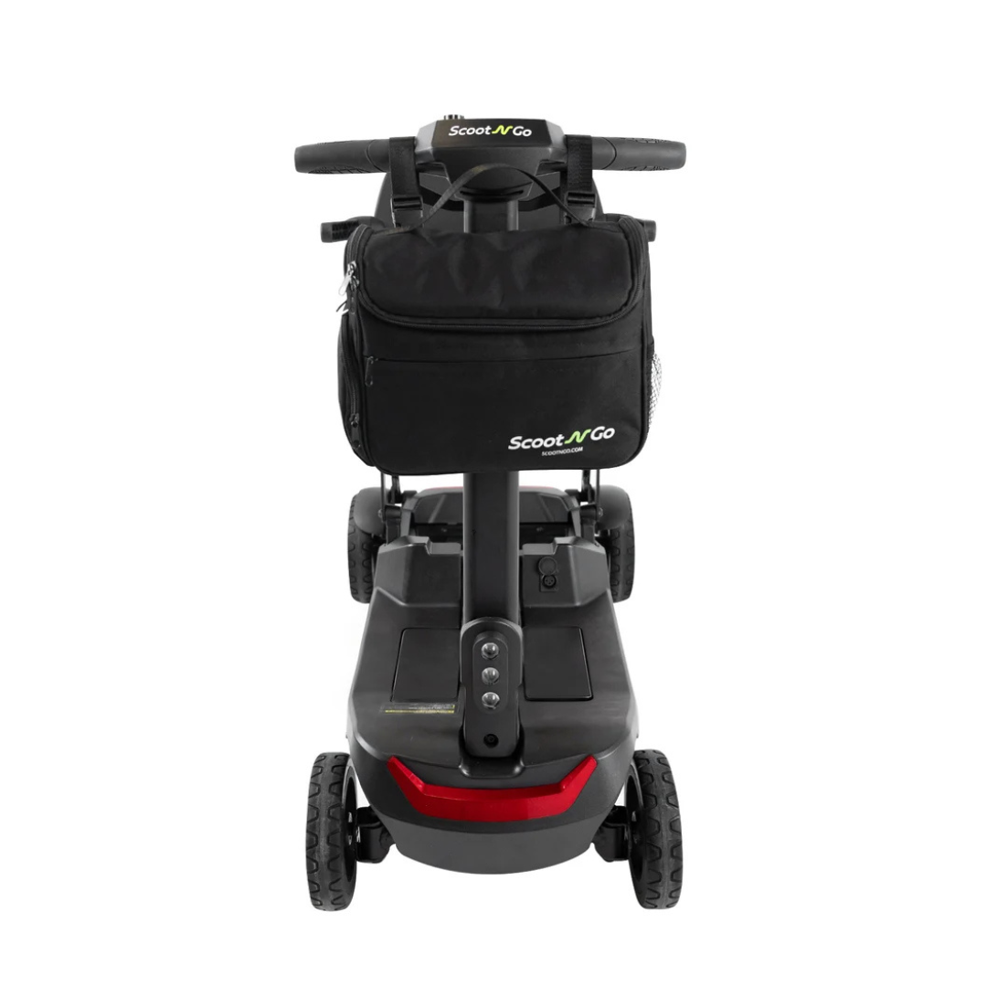 Front view of a compact black mobility scooter with a Front Basket Bag/Battery Bag for ScootNgo Lite/Voyager made from durable Oxford cloth attached to the handlebar, labeled Scoot N Go. This versatile mobility scooter accessory features four wheels and a sturdy base.