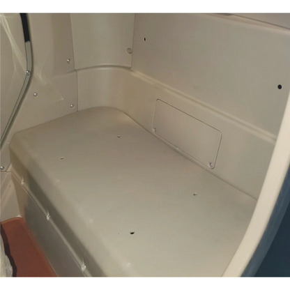 Inside the beige portable restroom, its bench-like seat and rectangular side panel echo the sleek minimalism of a GIO Golf Fully Enclosed Mobility Scooter. Neutral lighting accentuates its smooth surfaces and simple design.