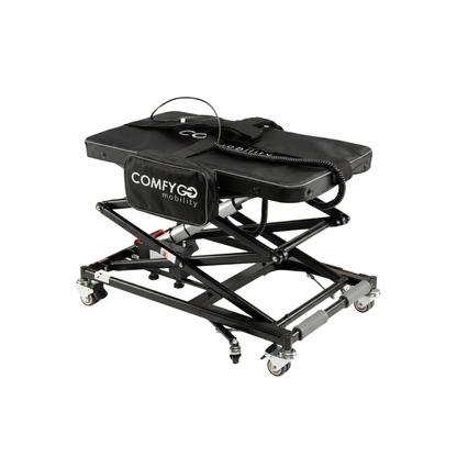 A ComfyGo GO-Lift Portable Lift for Electric Wheelchairs and Scooters, featuring a sturdy metal frame, caster wheels, padded top, handle, and storage pouch in black—perfectly designed for effortless transport and convenience when moving your mobility device.