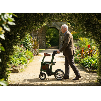 A man pushes a green uplivin Gavo 2-in-1 Hybrid Rollator & Wheelchair along a gravel path in a garden.