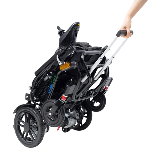 A person pulls the compact, folded Glide Care G-5 Lightweight Foldable Electric Wheelchair by its extended handle, highlighting its easy portability and travel-friendly design.