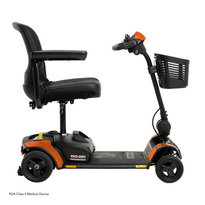 The Pride Mobility Go Go Elite Traveller® 2 Platinum Scooter is shown in profile against a white background, featuring a black and orange design with a padded seat, armrests, backrest, and front basket.