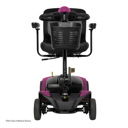 Rear view of the Pride Mobility Go Go Elite Traveller® 2 Platinum Scooter with black seat, armrests, magenta accents on handle and body, four wheels. FDA Class II Medical Device label visible in the corner.
