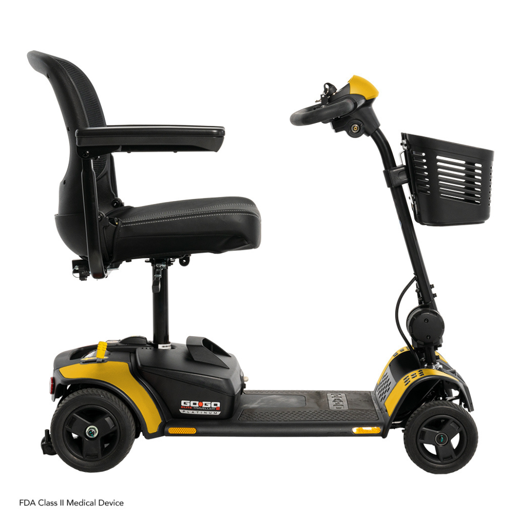 A side view of a black and yellow Pride Mobility Go Go Elite Traveller® 2 Platinum Scooter with a padded seat, armrests, three wheels, handlebars, front basket, and EZ Turn technology for enhanced mobility assistance.