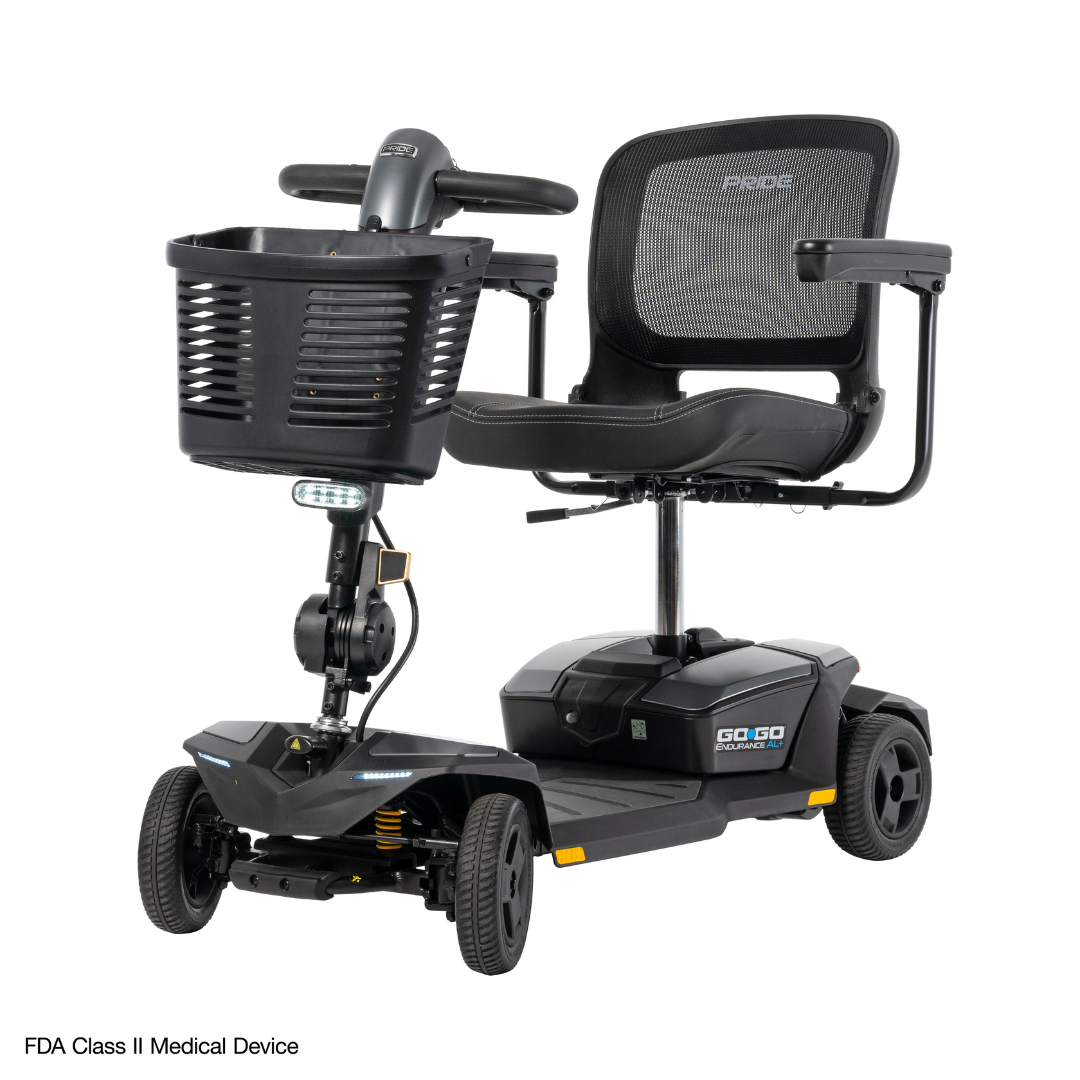 The Pride Mobility Go Go® Endurance AL+ Power Scooter is a black, four-wheeled FDA Class II device with a mesh seat, armrests, front basket, headlight, handlebars, and an Inter font dashboard display for clarity.