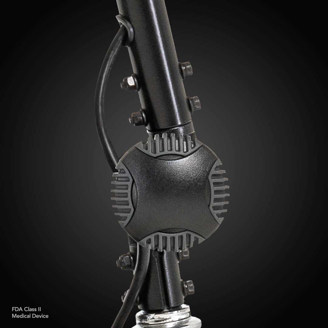 Close-up of a black Pride Mobility Go Go® Ultra X 4-Wheel Scooter, labeled as an FDA Class II Medical Device with a central cylindrical component and attached cables, showcasing design efficiency similar to economy-class scooters against a dark background.