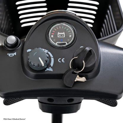 Close-up of the Pride Mobility Go Go® Ultra X 3-Wheel Scooters control panel, showcasing a sleek design with a speed dial, battery meter, and ignition key. This economy-class scooter features clear labeling for easy navigation and functionality.