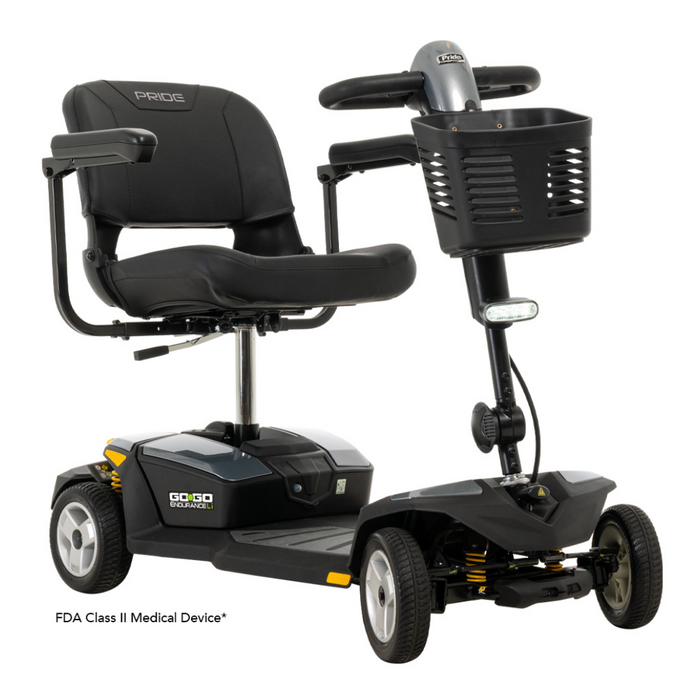 The Pride Mobility Go Go® Endurance Li 4-Wheel Scooter, an FDA Class II Medical Device, is a black scooter with Comfort-Trac Suspension, offering a smooth ride. It features a cushioned seat, armrests, and steering with a basket for reliable mobility.