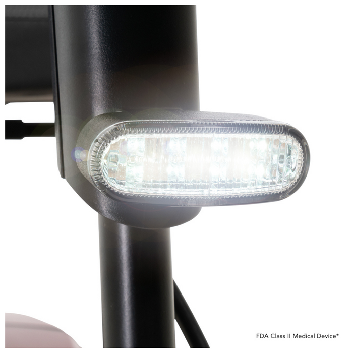 Close-up of a bright, oval LED light on the black metal frame of the Pride Mobility Go Go® Endurance Li 4-Wheel Scooter against a white background. The light, powered by a lithium battery, emits a strong white glow and appears to be part of this mobility device.