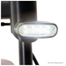 Close-up of a bright, oval LED light on the black metal frame of the Pride Mobility Go Go® Endurance Li 4-Wheel Scooter against a white background. The light, powered by a lithium battery, emits a strong white glow and appears to be part of this mobility device.