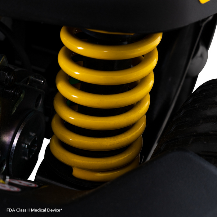 Close-up of a bright yellow coil spring on the Pride Mobility Go Go® Endurance Li 4-Wheel Scooter with Comfort-Trac Suspension, prominently featured against dark metal components to highlight advanced lithium battery technology for enhanced performance.