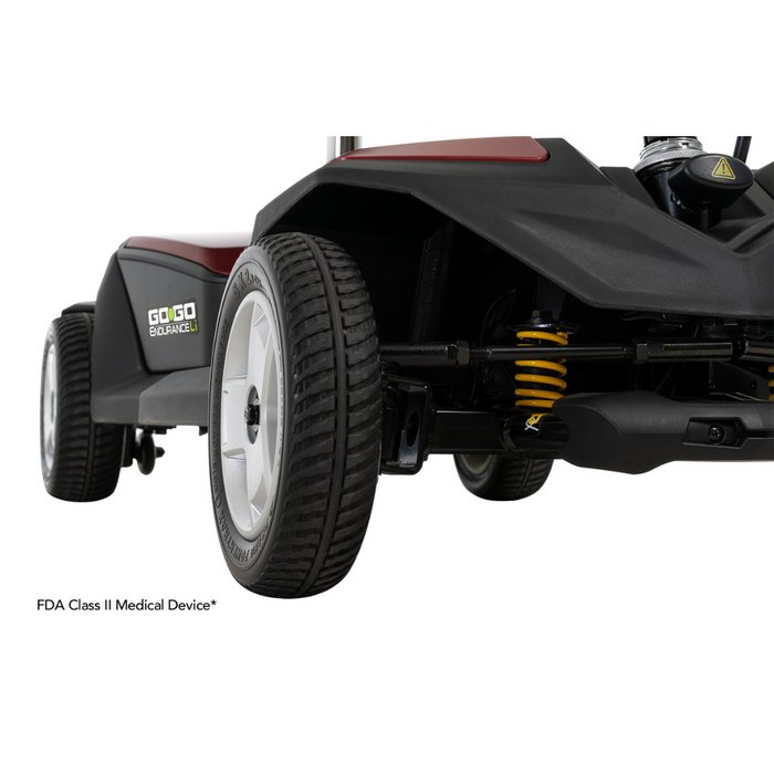 Close-up of a Pride Mobility Go Go® Endurance Li 4-Wheel Scooter, showcasing its Comfort-Trac Suspension and durable wheels. This FDA Class II medical device with a lithium battery highlights design details and endurance.