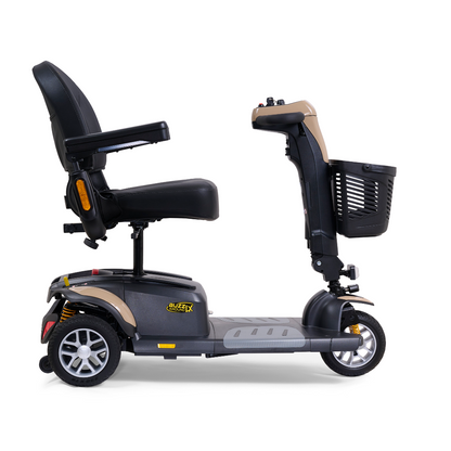 A side view of the Golden Buzzaround LX GB119 - Heavy Duty 3 Wheel Portable Mobility Scooter displays a luxurious design featuring a black seat with armrests, a front basket, and a metallic frame. The scooter includes a central tiller for steering and small, sturdy wheels for enhanced mobility.
