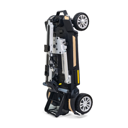 An image of a compact black and silver Golden Technologies Portable Buzzaround GB120 Carry-On Travel Scooter standing upright on its two wheels. The scooter features metallic components, a handle, and visible wheels, displayed against a white background.